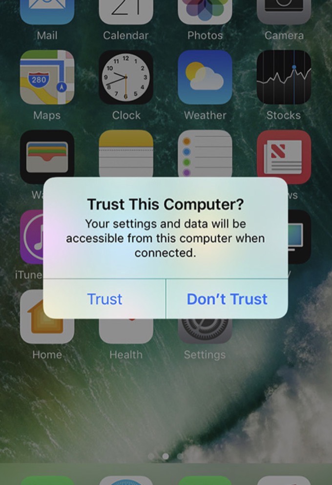 The Trust This Computer prompt on an iPhone home screen, with Trust and Do Not Trust buttons